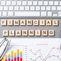 Financial planning concept with letters on cubes. Still life of office workplace. Flat lay grey surface with computer keyboard, calculator and analytic report. Company development and consulting.